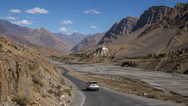 Spiti Valley road beside a cold-desert river and Buddhist monastery